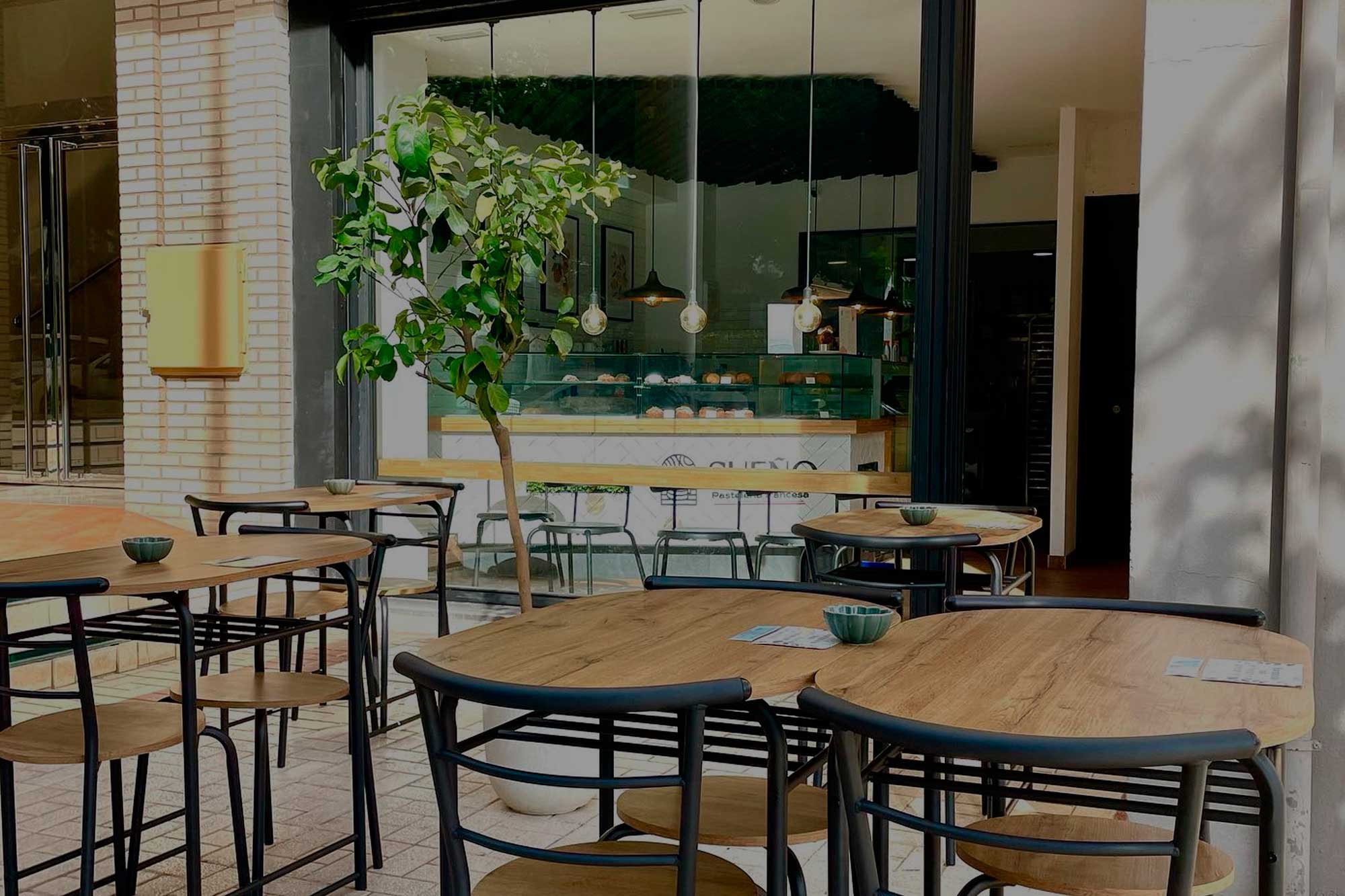 La salle de Sueño Pastelería Francesa, tables rondes et grandes baies vitrées