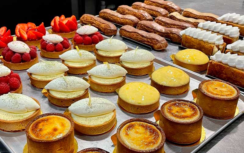 Vitrine garnie de tartelettes au citron, aux fraises et de flans